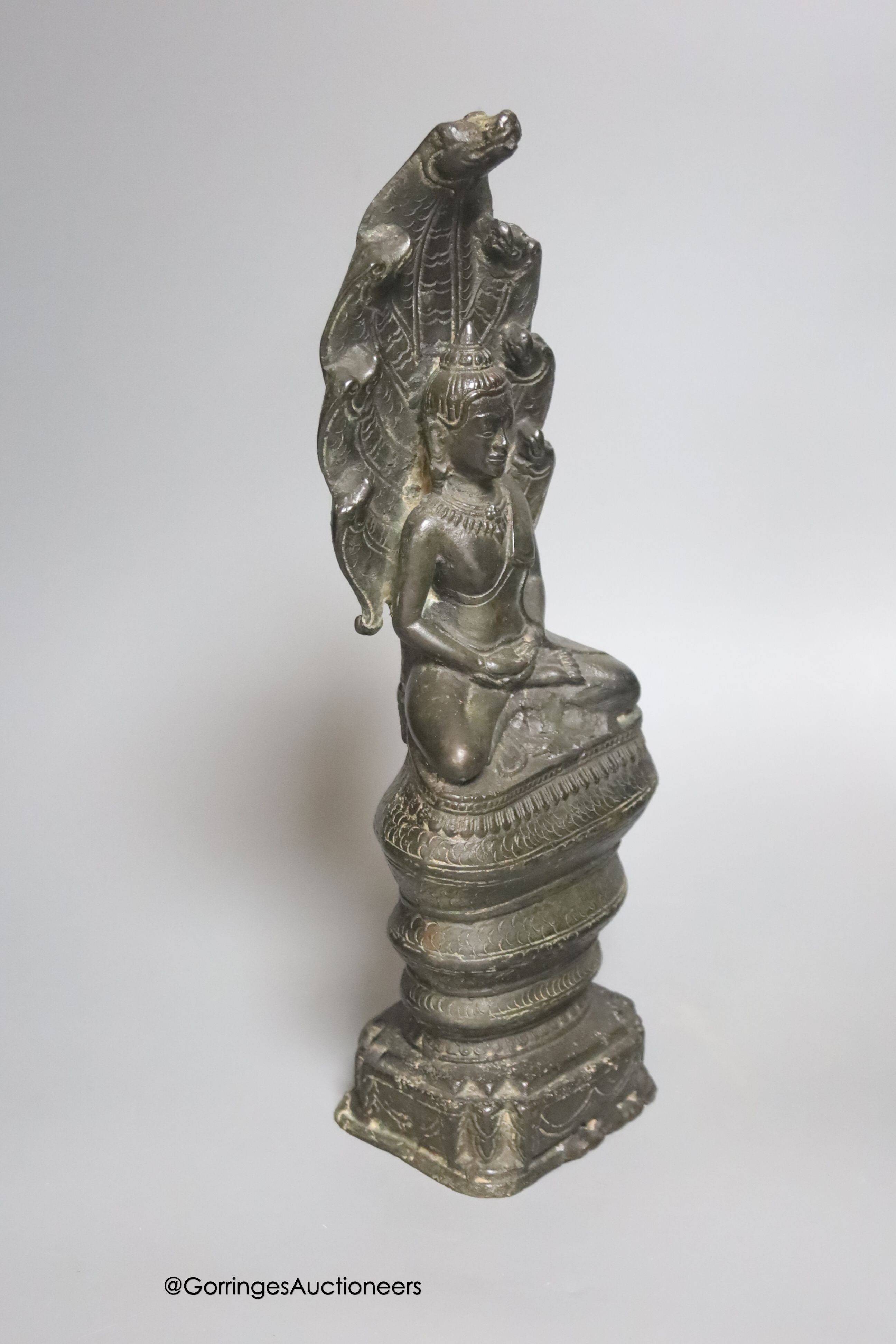 An 18th/19th century Cambodian bronze seated figure of Buddha Shakyamuni and the cobra Mucalinda 33cm